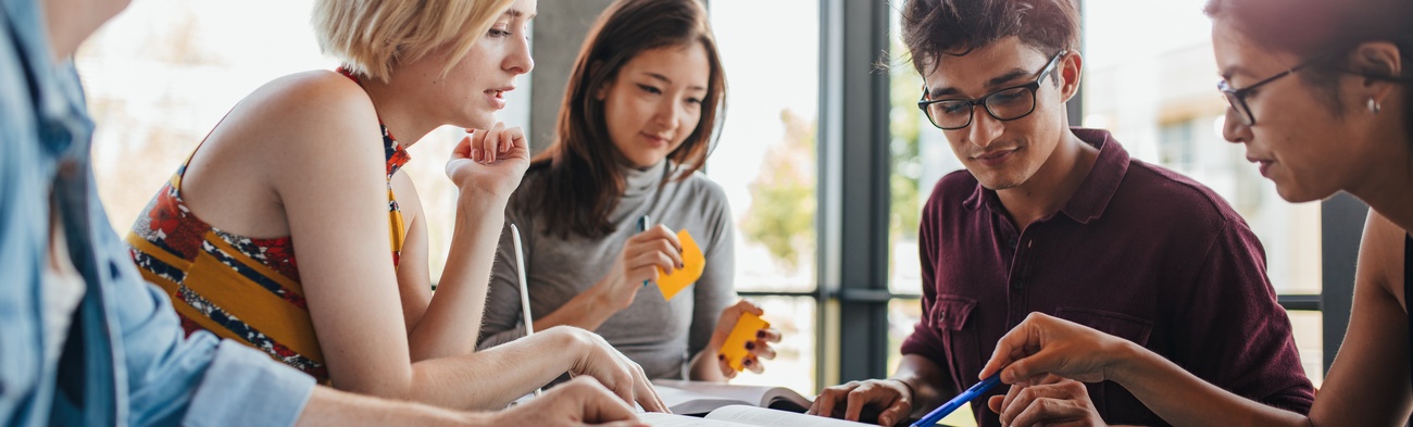 Diverse Gruppe von Studenten lernen in einer Bibliothek