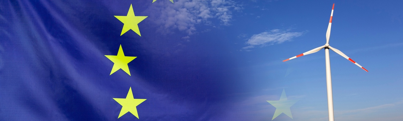 Europaflagge löst sich in ein Landschaftsbild mit Windrad auf