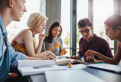 Diverse Gruppe von Studenten lernen in einer Bibliothek