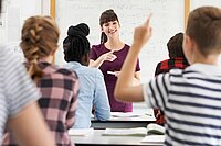 Schüler zeigt in einer Klasse auf