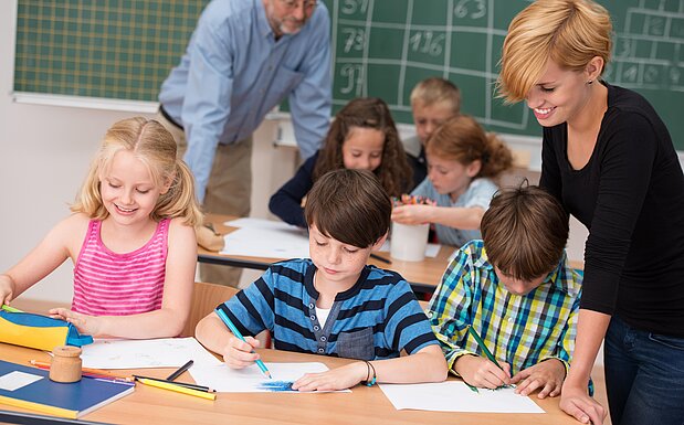 Eine Volksschulklasse wird von zwei Lehrern unterrichtet