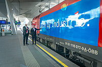 Eine ÖBB-Lok mit dem Schriftzug "Made by Industrie", davor stehen ÖBB CEO Andreas Matthä und IV-Präsident Georg Knill