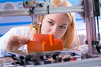 Junge Frau arbeitet mit 3D-Drucker